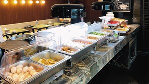 A buffet area with various food items and a seating area with tables and chairs. - chongqingyinshiguangjiangjingjiudian (Chongqing)