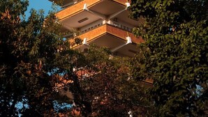 A multi-story building with a series of balconies and a chimney. - chongqingyinshiguangjiangjingjiudian (Chongqing)