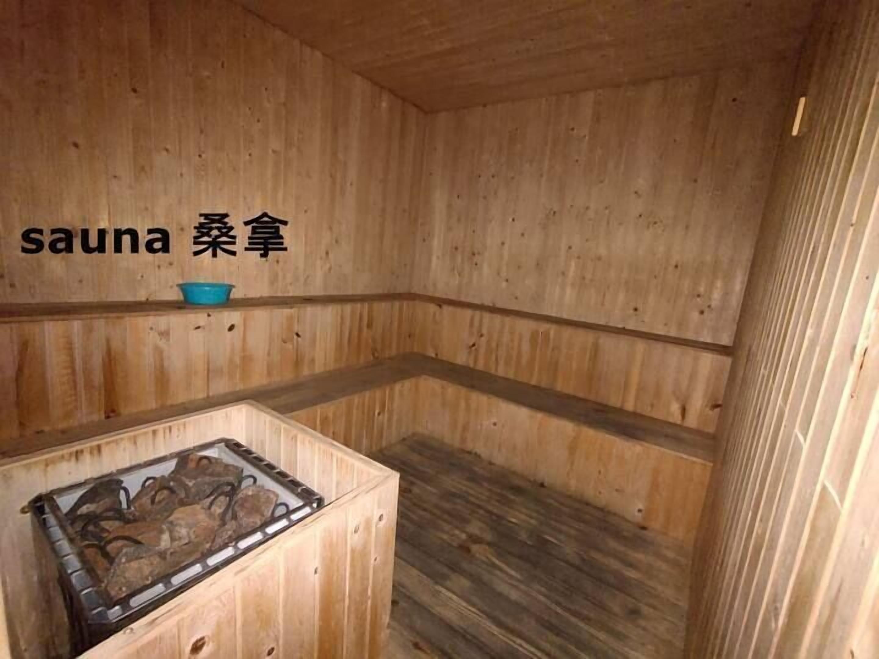 Una sauna de madera con bancos y un calentador.