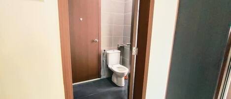 A small bathroom with a toilet and a door.