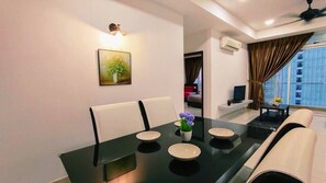 A dining area with a black table, white chairs, and a vase of flowers.