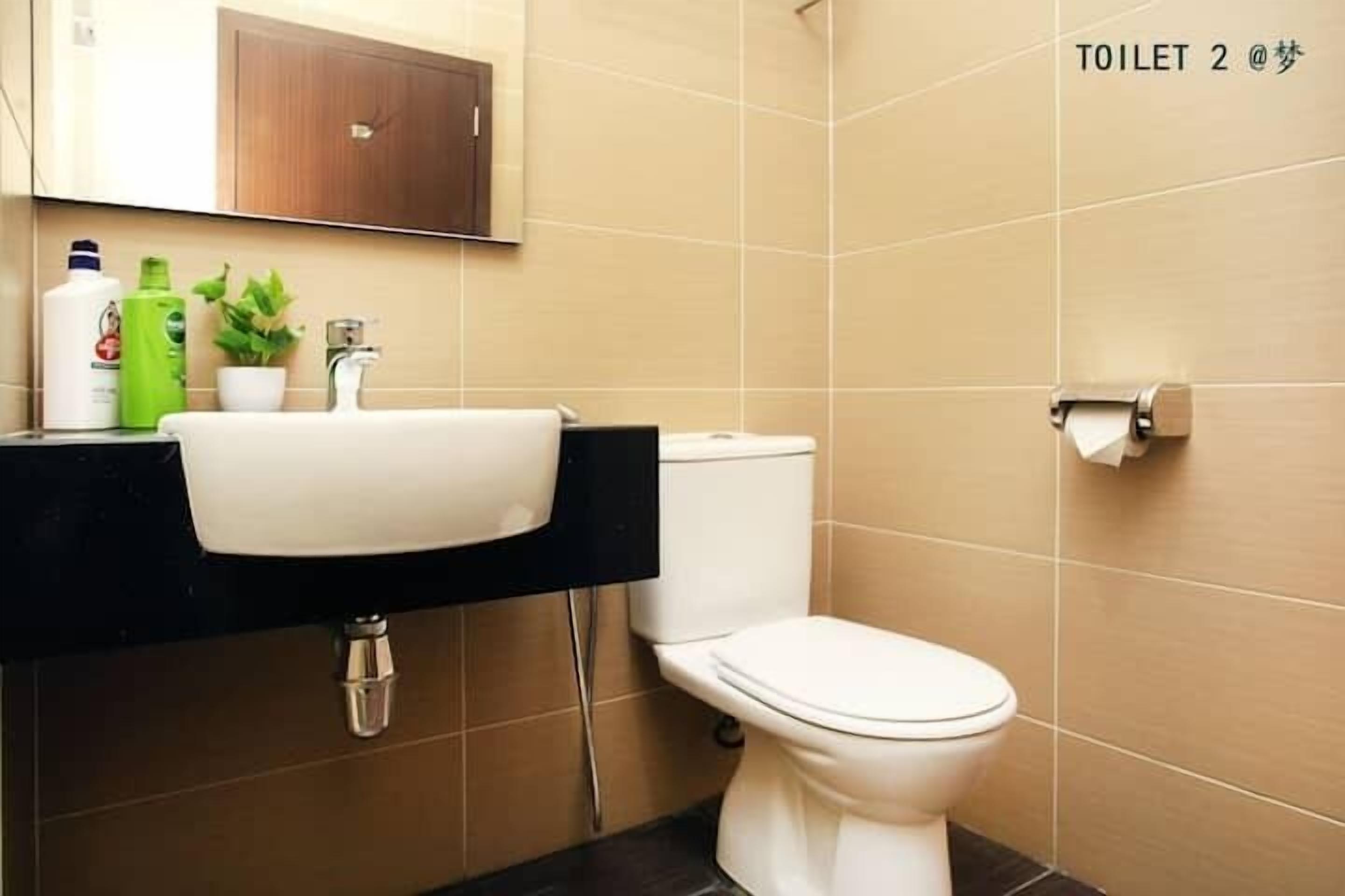 A modern bathroom with a white sink, a toilet, and a mirror above the sink.