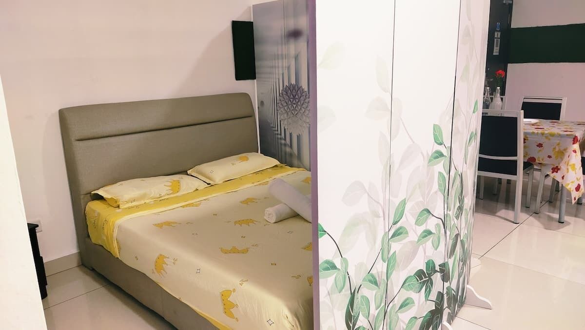 Een slaapkamer met een bed, een kledingkast en een zithoek met een tafel en stoelen.
