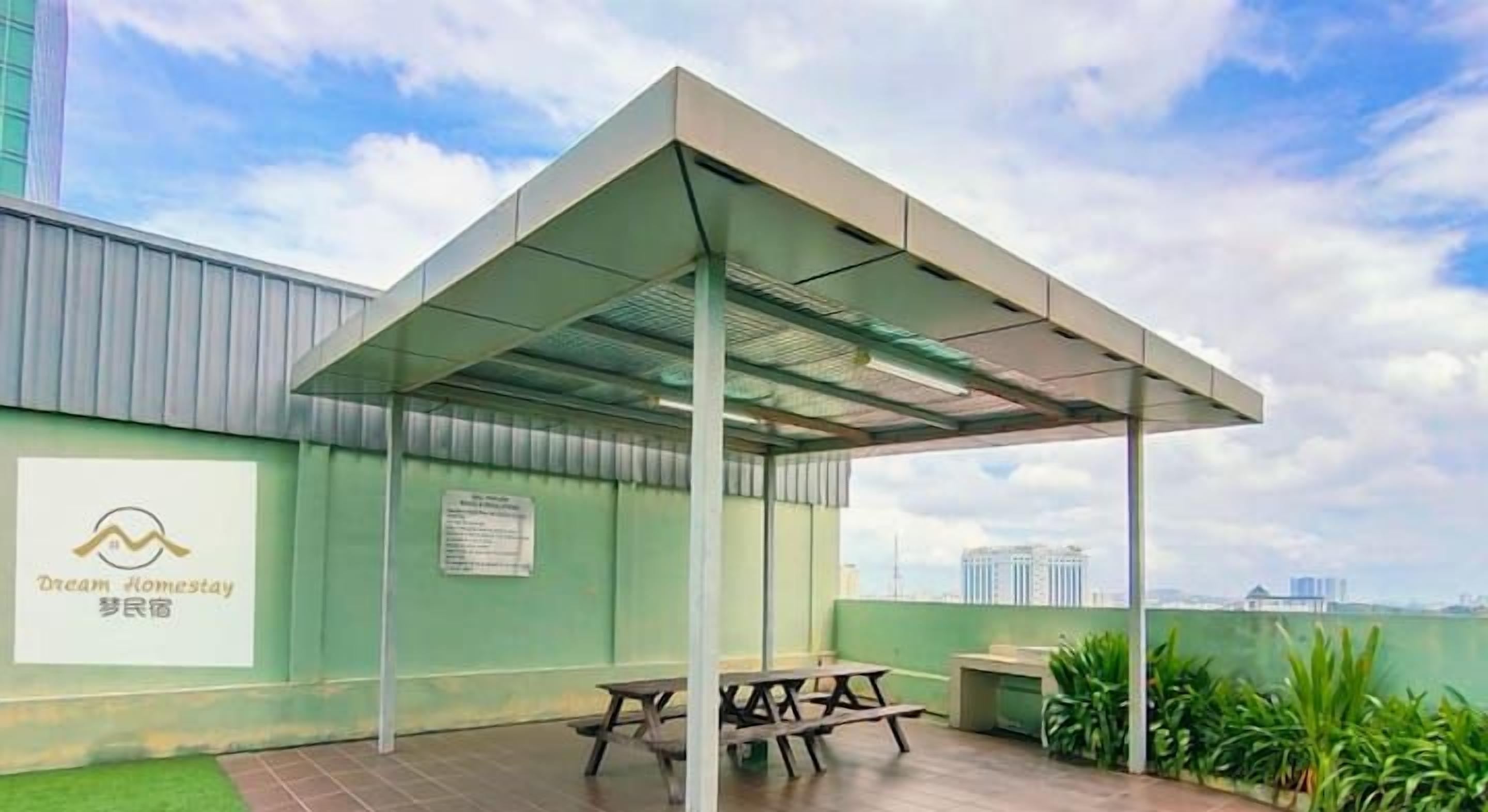A BBQ area with a covered seating arrangement and a view of the city skyline.