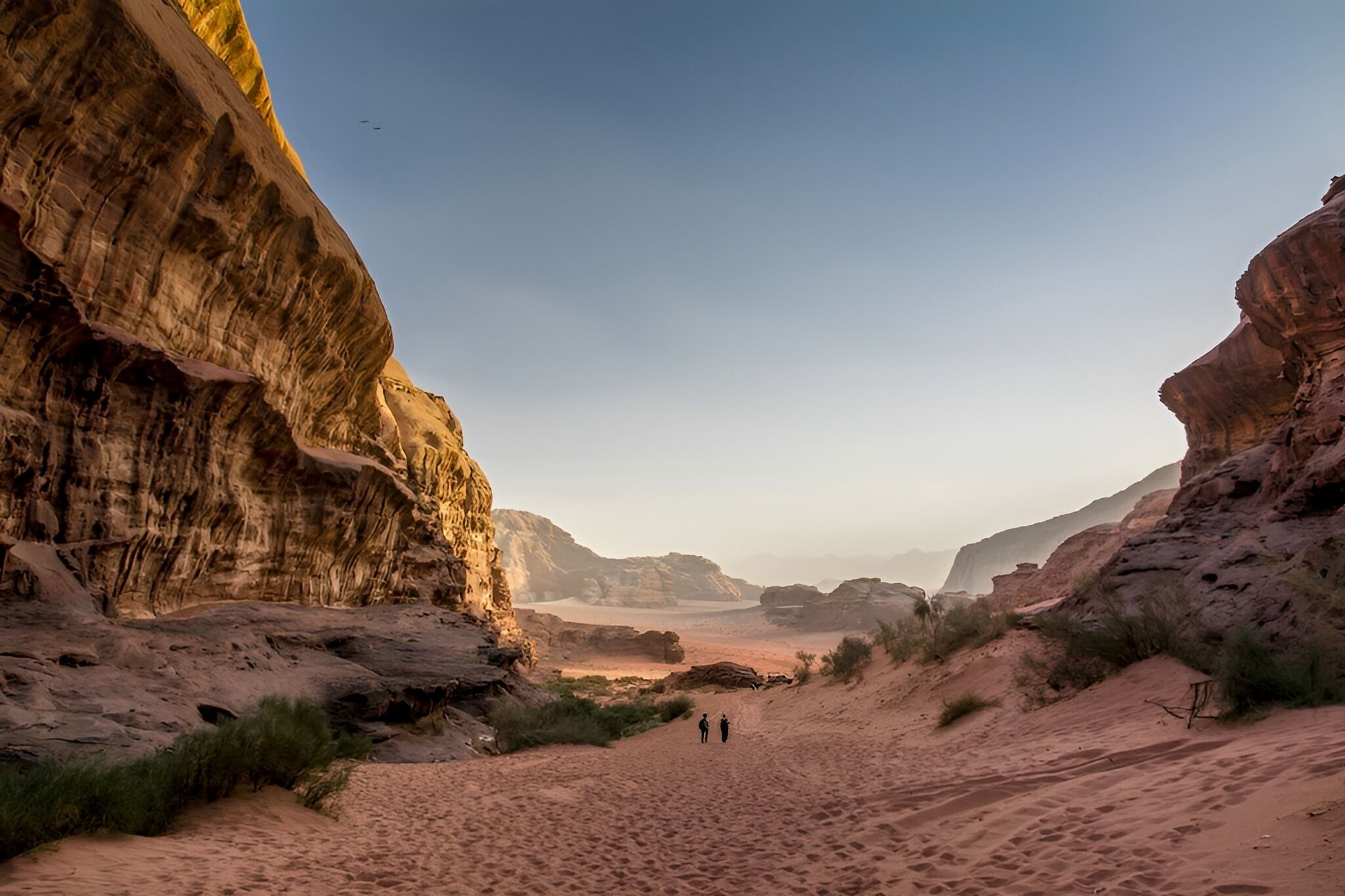 A desert landscape with rock formations and a clear sky.