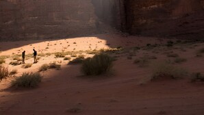 A canyon with two large rock formations and a narrow passageway. - SunCity Camp (Wadi Rum)