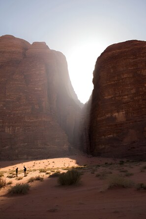 A canyon with two large rock formations and a narrow passageway. - SunCity Camp (Wadi Rum)