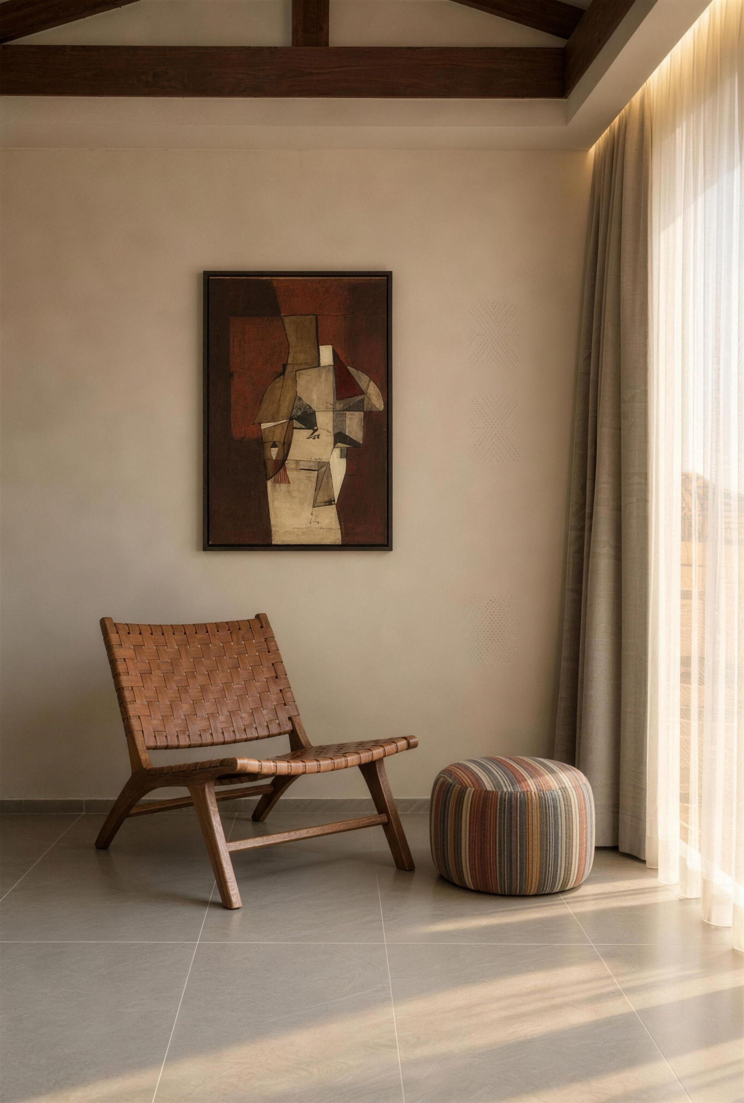 A minimalist room with a modern chair, a colorful ottoman, and a geometric abstract painting on the wall.