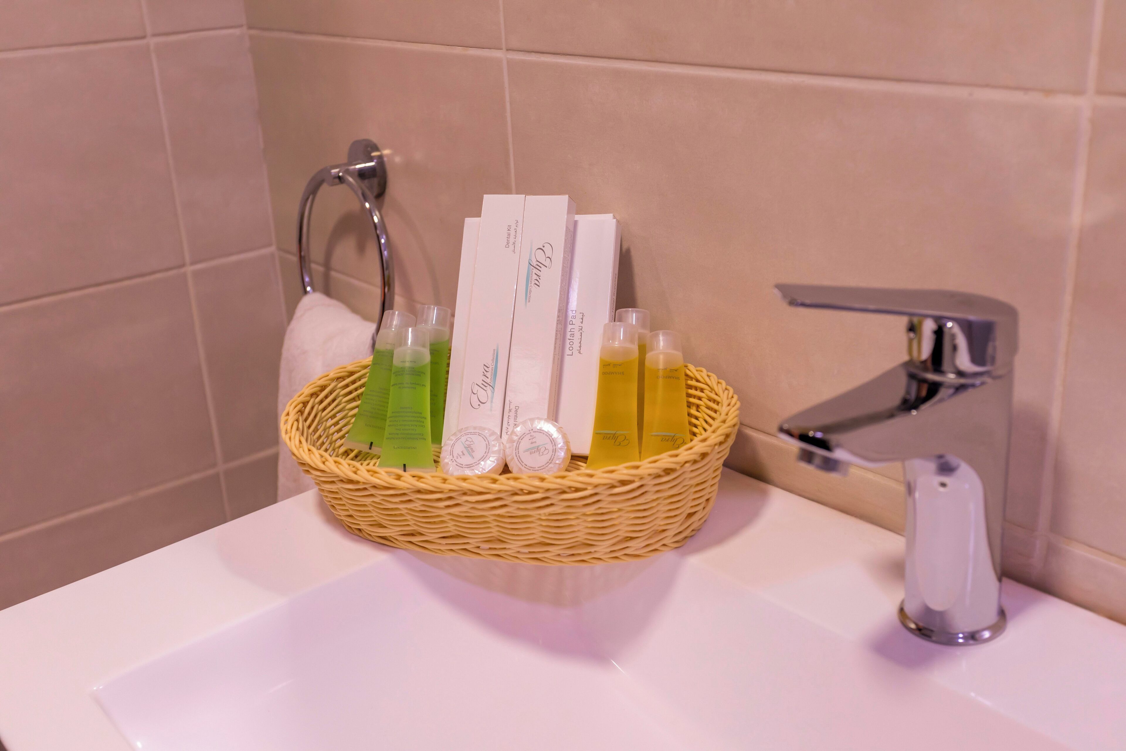 A bathroom sink with a wicker basket containing toiletries.