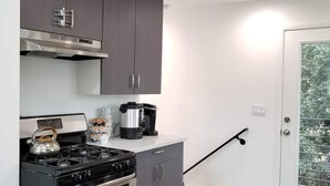 A modern kitchen with grey cabinets, stainless steel appliances, and a wooden floor. - Kobe Bryant vacation getaway - 5 minutes to Rodeo Drive, Game console, Hot Tub (Beverly Hills)