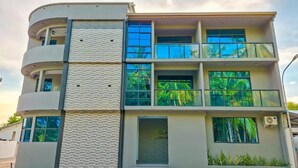 Un immeuble à plusieurs étages doté d’une façade incurvée, de grandes fenêtres et de balcons.