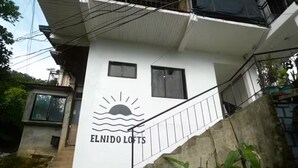 A building with a staircase leading to a balcony, labeled "ELNIDO LOFTS". - El Nido Loft Apartment (El Nido)