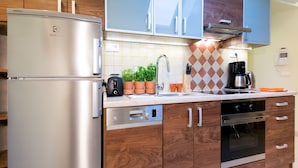A modern kitchen with stainless steel appliances, wooden cabinets, and a tiled backsplash. - Vanilla 3, 4bdr 2bth apartment 5min to Krakow's Main Square (Kraków)