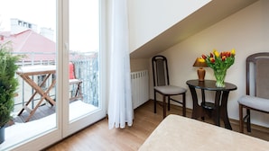 A balcony with a view of buildings, a table with a lamp and flowers, and two chairs. - Vanilla 3, 4bdr 2bth apartment 5min to Krakow's Main Square (Kraków)