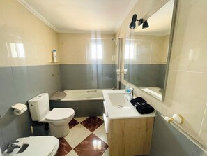 Een haardroger, handdoeken, zeep, toiletpapier