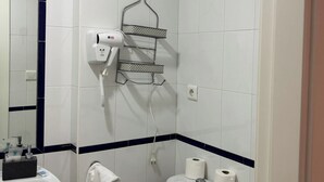 A bathroom with a white sink, toilet, and a hairdryer mounted on the wall. - ISLANTUR BELLAMAR (Lepe)