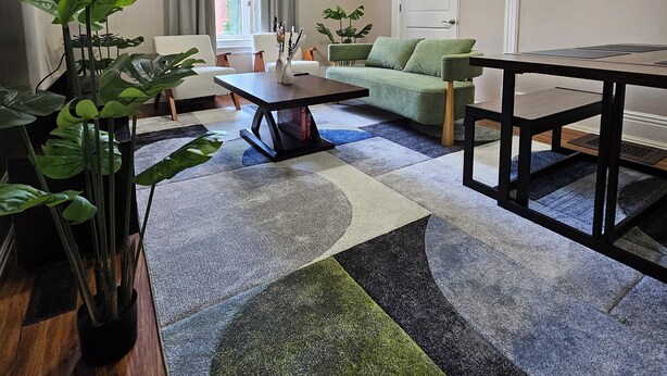 A modern living room with a sofa, coffee table, and a dining table.