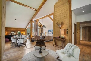 Amplio espacio tipo loft con techos altos, vigas de madera y una chimenea acogedora.