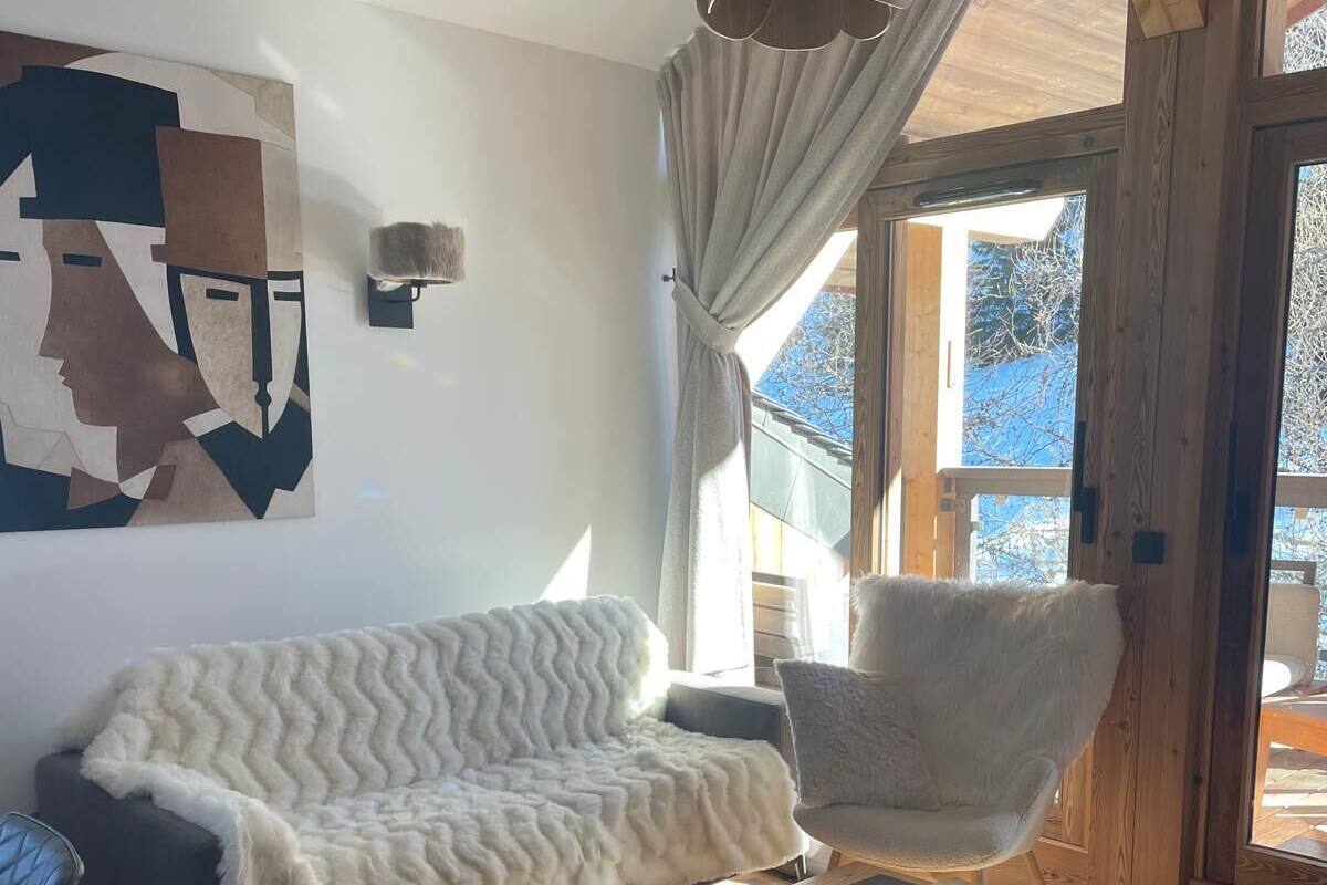 Un saló acollidor amb un sofà, una butaca, una taula de centre de fusta i un moqueta de pell de vaca.