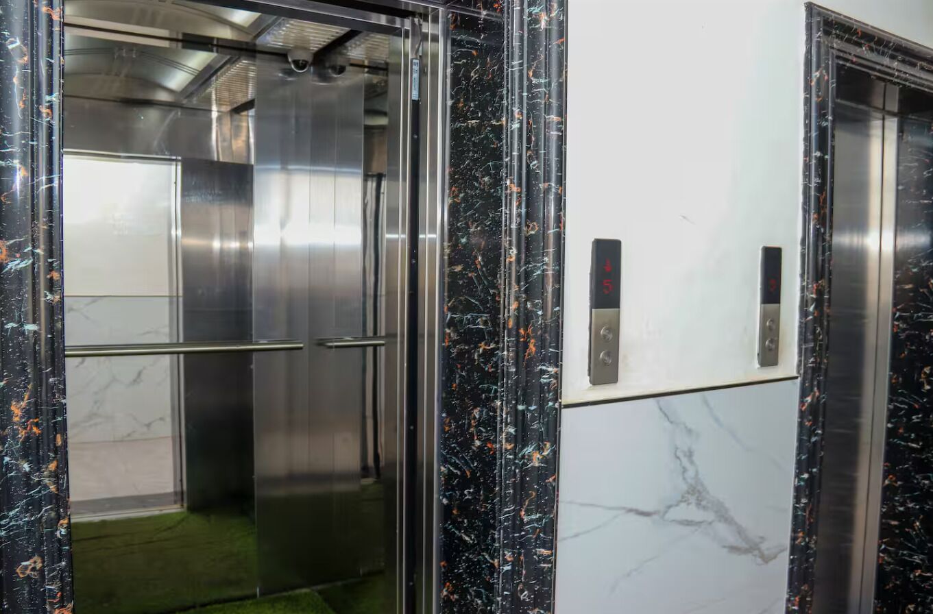 An elevator with metallic interior and marble accents.