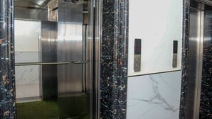 An elevator with metallic interior and marble accents.