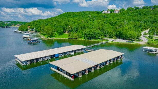 Kelluva hotelli, jossa on useita kerroksia, ja sen ympärillä on järvi sekä metsäinen kukkula.