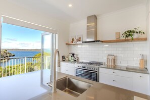 Una cucina moderna con vista sul mare, un lavello in acciaio inossidabile e un forno integrato.