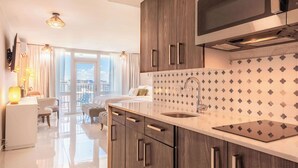A modern kitchen with wooden cabinets, a stainless steel microwave, and a patterned backsplash.