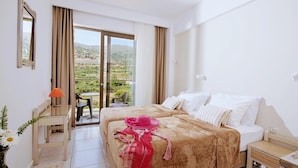 A hotel room with a bed, a desk, a chair, a lamp, and a view of the outdoors. - HERMES HOTEL MALIA (Malia)