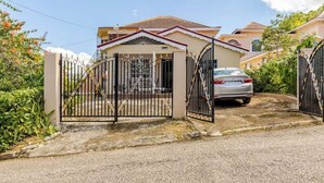 Un lotissement résidentiel fermé, avec une voiture garée et une maison dont le toit est recouvert de tuiles.
