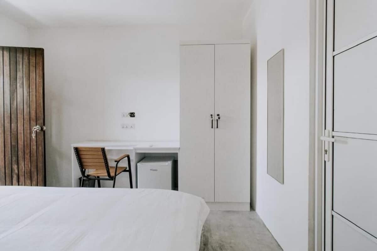 Un dormitorio con cama, escritorio y armario.