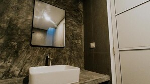 A bathroom with a rectangular sink, a mirror, and a marble wall. - Moro Kihaadhoo (Kihaadhoo)