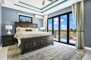 Un dormitorio con una cama grande, una mesita de noche, una ventana y vistas al exterior.