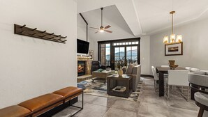 A spacious living room with a fireplace, a dining area, and a seating area with a bench.