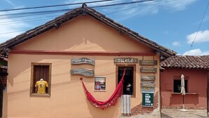 A building with a sign for 'Casa de Geninho' and 'Tillele' hotel. - Casa do Geninho Pousada e Camping  (Lima Duarte)