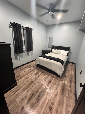 A bedroom with a bed, a ceiling fan, and a wooden floor. - Red’s Baile Stunning Mexico Country Home, Bar, Games, Fitness, Pond & Fire pit. (Mexico)