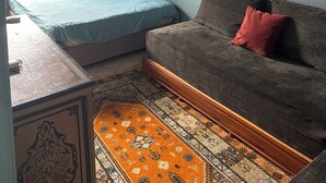 A room with a bed, a sofa, a patterned rug, and two framed pictures on the wall. - BEACH FRONT PROPERTY
Serene 3-bedroom house with AC in Skhirat (Skhirat)