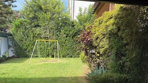 A backyard with a swing set, a hose, and a garden with various plants. - BEACH FRONT PROPERTY
Serene 3-bedroom house with AC in Skhirat (Skhirat)