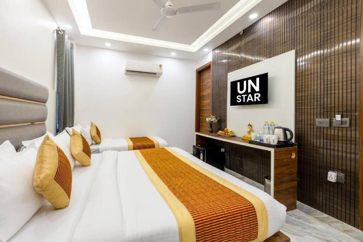 A hotel room with a bed, a desk, a mirror, and a wall-mounted sign.