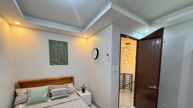 Une chambre à coucher avec un lit, une table de chevet et une horloge murale.