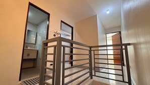 Un appartement moderne doté d’un escalier, d’une salle de bain avec un meuble-lavabo en marbre et d’une prise électrique visible.