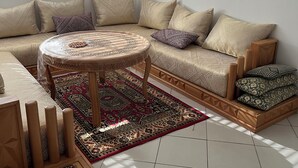 A modern living room with a sectional sofa, a round coffee table, and a patterned rug.