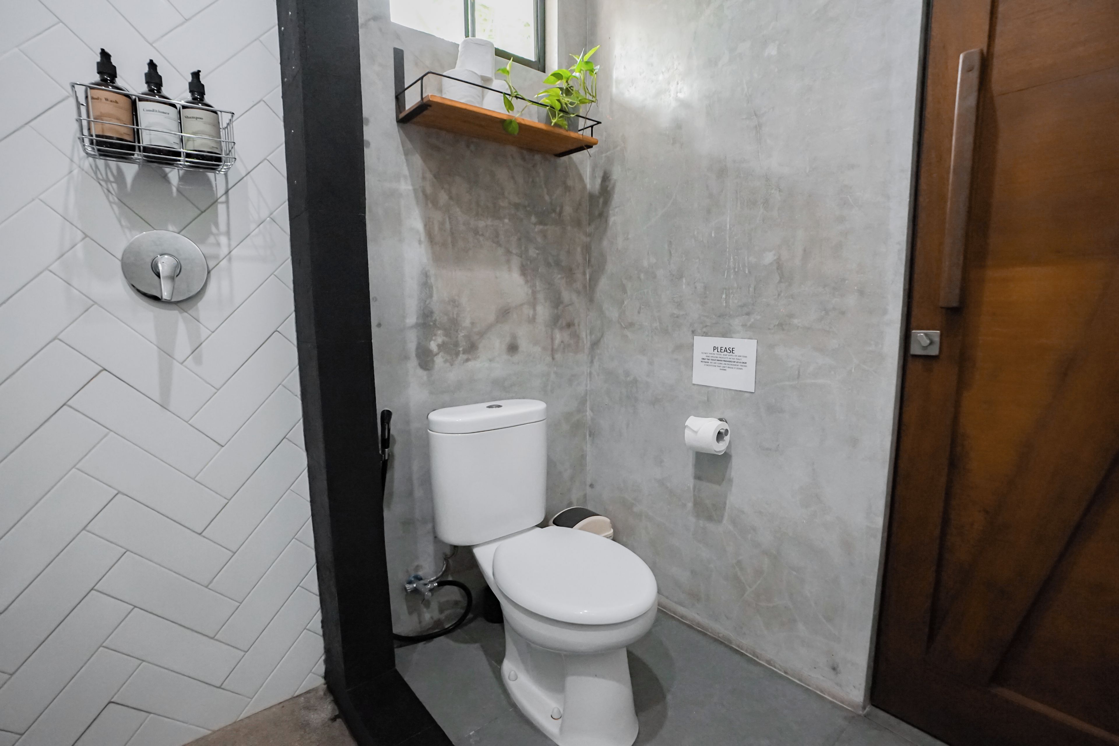 Een badkamer met een toilet, een handdroger en een zeepdispenser op een muur.