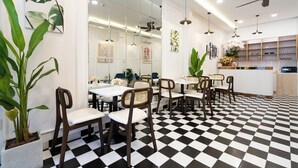 Un restaurante con piso a cuadros, sillas de madera y una zona de bar con estantes.