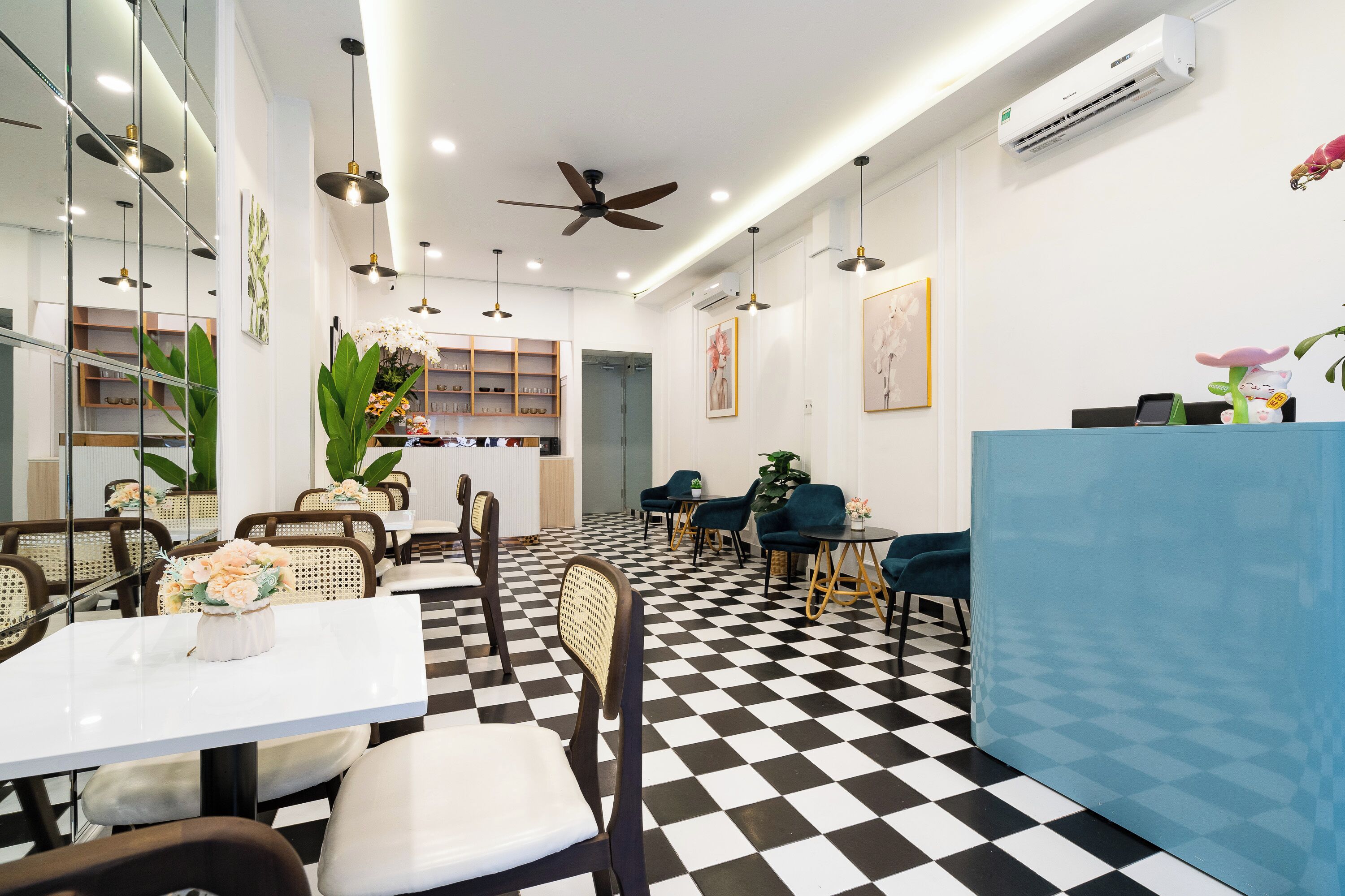 A modern dining area with checkered flooring, white walls, and a blue counter.