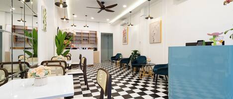 A modern dining area with checkered flooring, white walls, and a blue counter.
