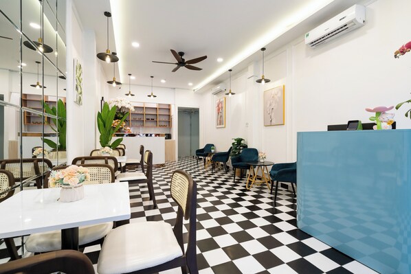 A modern dining area with checkered flooring, white walls, and a blue counter.