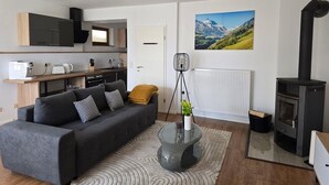 A modern living room with a sofa, coffee table, and a fireplace. - Apartment on the mountain Schloßberg with beautiful view Pet friendly (Heideck)