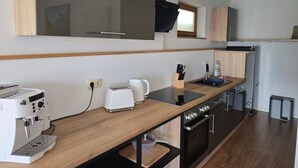 A modern kitchen with a built-in oven, a coffee machine, and a toaster. - Apartment on the mountain Schloßberg with beautiful view Pet friendly (Heideck)
