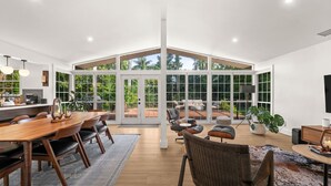A spacious interior with a large dining area, seating arrangements, and a view through expansive windows.